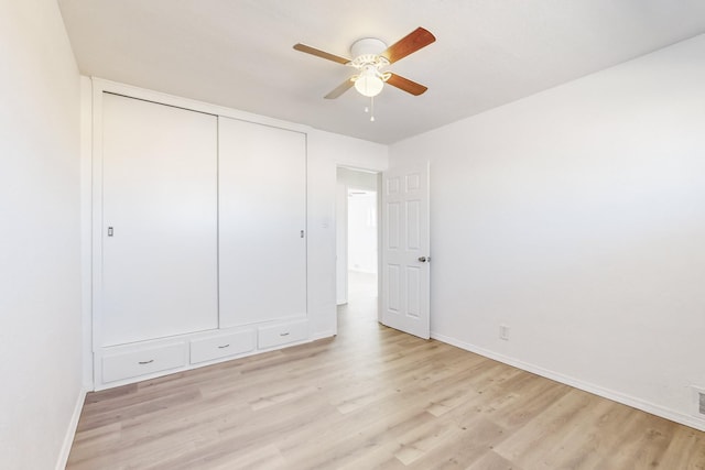 unfurnished bedroom with ceiling fan, a closet, and light wood-type flooring