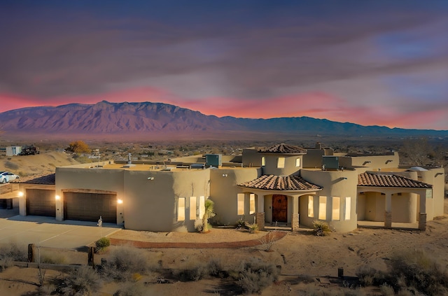 view of front of property with a garage, a mountain view, and stucco siding