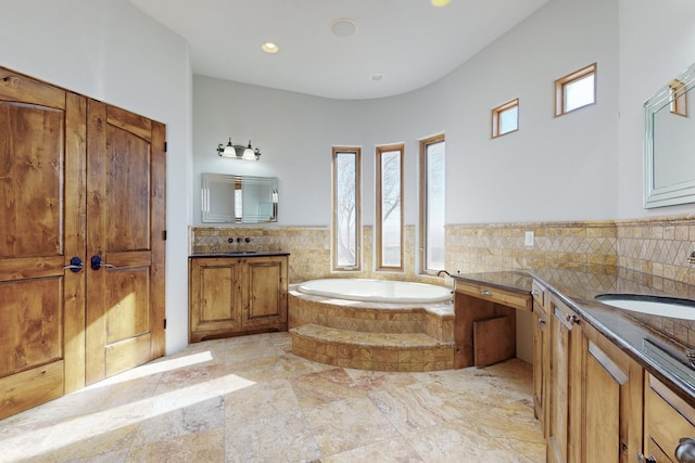 bathroom with a garden tub and vanity