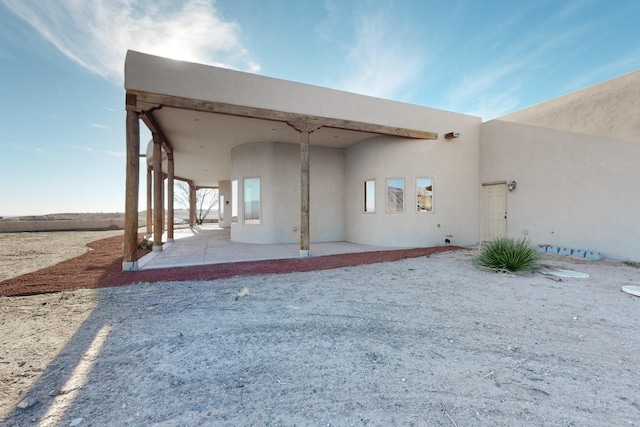 rear view of property featuring a patio area and stucco siding