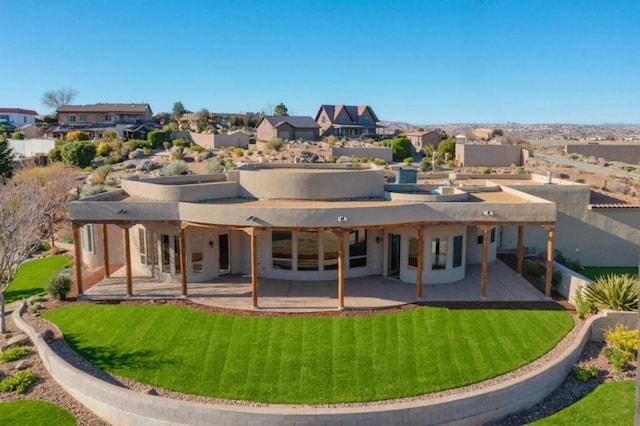 back of house with a residential view, a lawn, and a patio area