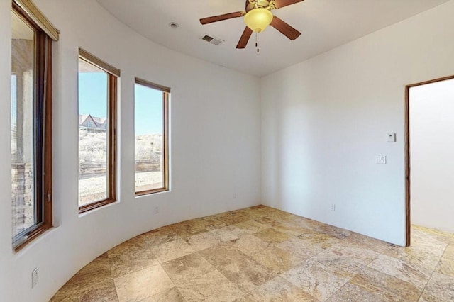 unfurnished room featuring visible vents and a ceiling fan