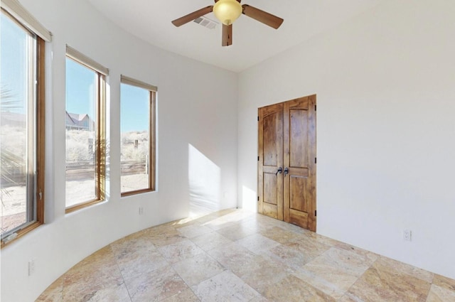 unfurnished room with visible vents and a ceiling fan