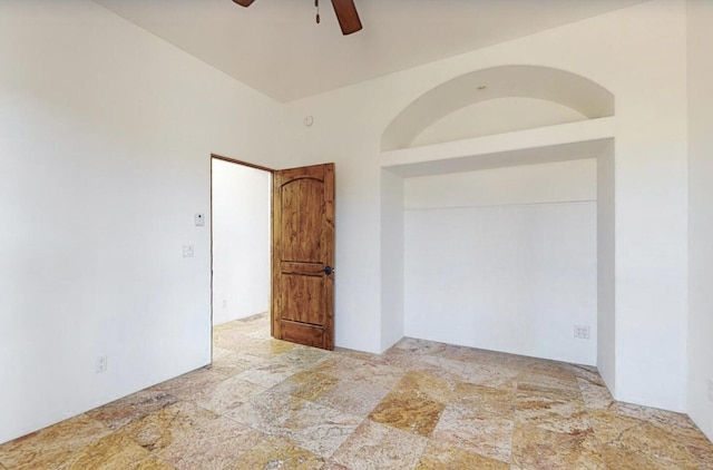 unfurnished room featuring stone finish floor and a ceiling fan