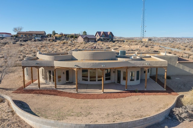 back of house with stucco siding and a patio