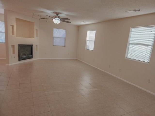 unfurnished living room featuring a textured ceiling, ceiling fan, and light tile patterned flooring