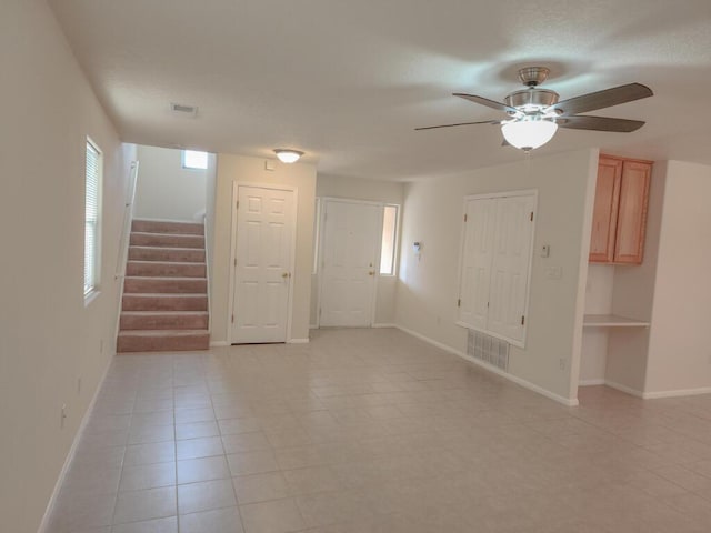 tiled empty room featuring a wealth of natural light and ceiling fan