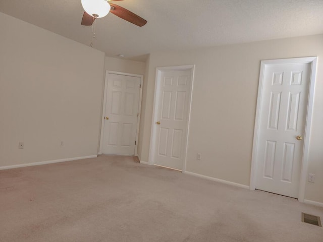 empty room featuring ceiling fan and light carpet