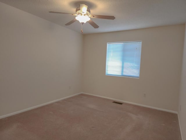 empty room featuring carpet flooring and ceiling fan