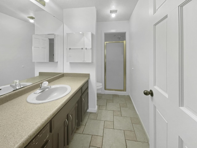 bathroom with a shower with door, vanity, a textured ceiling, and toilet