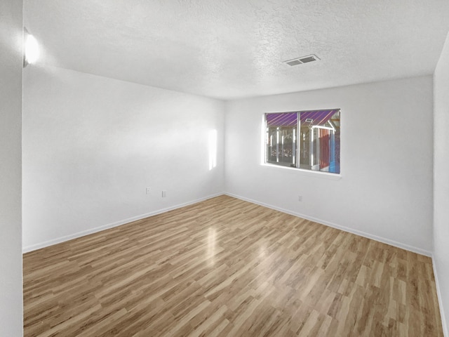 spare room with wood-type flooring and a textured ceiling