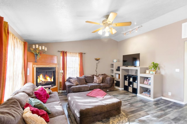 living room with a textured ceiling, hardwood / wood-style flooring, ceiling fan, and lofted ceiling