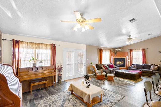 living room featuring a textured ceiling, ceiling fan, dark hardwood / wood-style flooring, and lofted ceiling