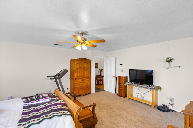 bedroom with ceiling fan, carpet floors, and a textured ceiling