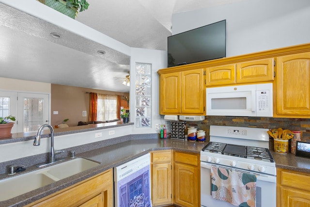 kitchen with white appliances, sink, and tasteful backsplash