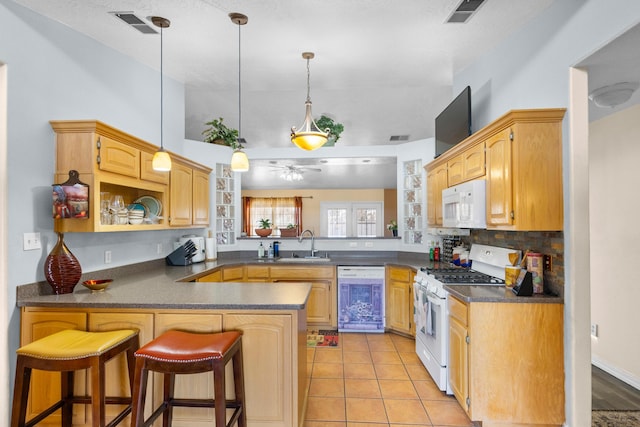 kitchen with kitchen peninsula, a kitchen breakfast bar, white appliances, ceiling fan, and pendant lighting