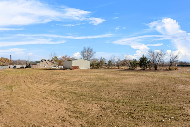 view of yard featuring a rural view and an outbuilding