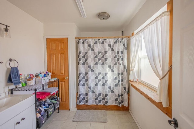 bathroom featuring tile patterned flooring, vanity, and walk in shower