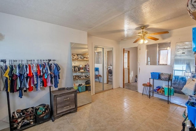 interior space with ceiling fan, a textured ceiling, and washer / clothes dryer