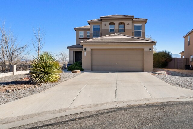 view of front of property featuring a garage and cooling unit