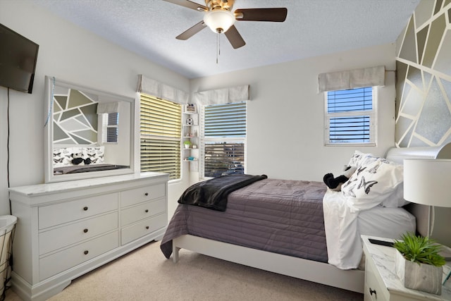 carpeted bedroom featuring ceiling fan and a textured ceiling