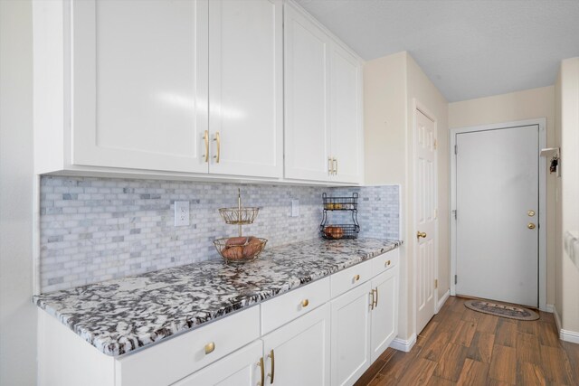 kitchen featuring white cabinetry, decorative backsplash, and light stone countertops