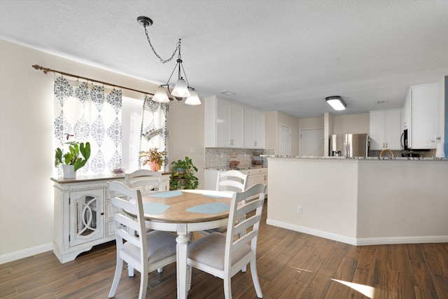 dining room featuring dark hardwood / wood-style floors and a textured ceiling