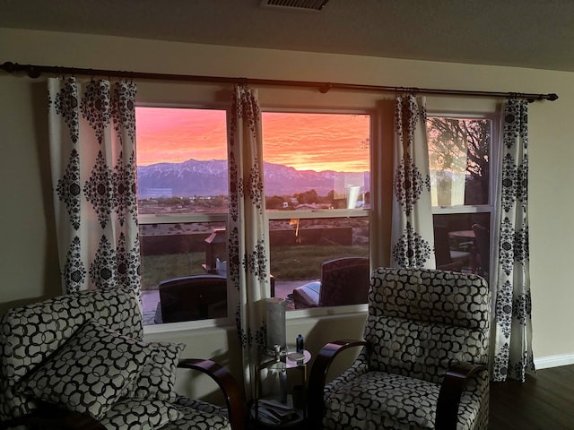 sitting room with hardwood / wood-style flooring and a mountain view