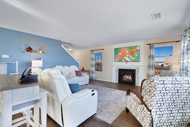 living room featuring dark wood-type flooring and a textured ceiling