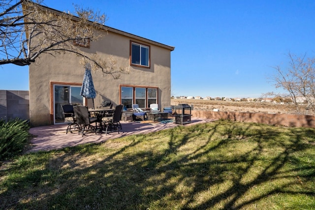 back of property with a yard and a patio area