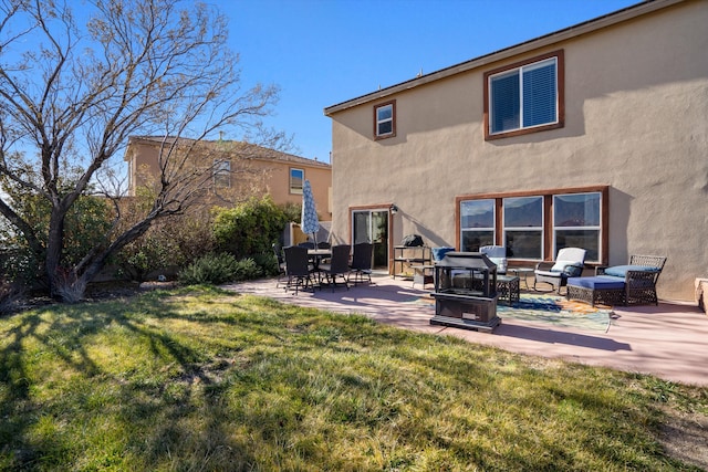 back of property with a lawn and a patio