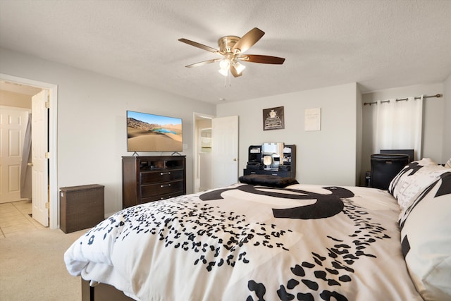 carpeted bedroom with ceiling fan and a textured ceiling