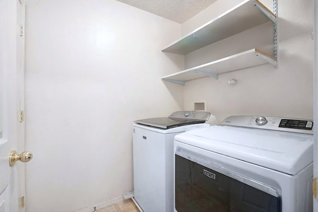 washroom featuring washing machine and clothes dryer and a textured ceiling