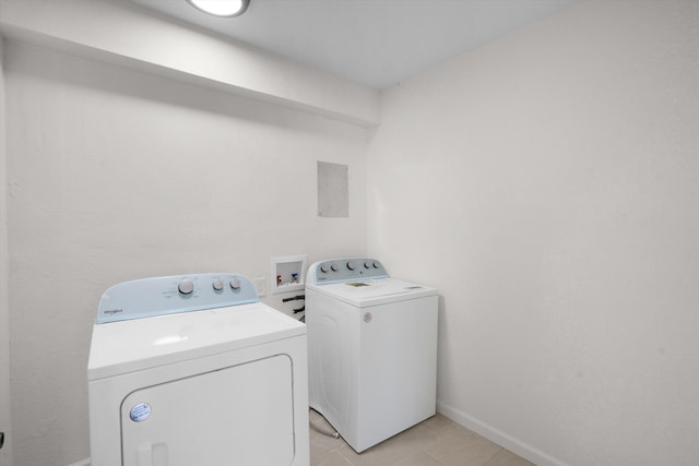 clothes washing area with light tile patterned flooring and independent washer and dryer