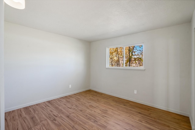 empty room featuring light hardwood / wood-style floors and a textured ceiling