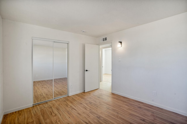 unfurnished bedroom featuring hardwood / wood-style flooring and a closet