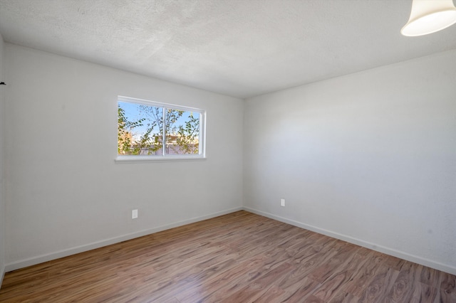 spare room with hardwood / wood-style floors and a textured ceiling