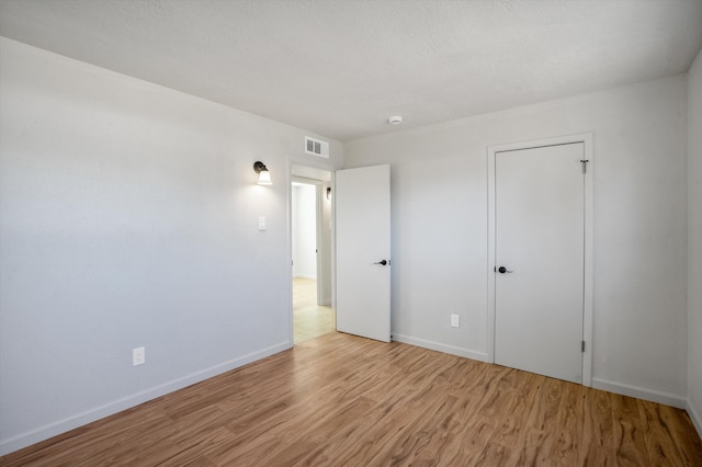 unfurnished bedroom featuring light hardwood / wood-style flooring and a textured ceiling