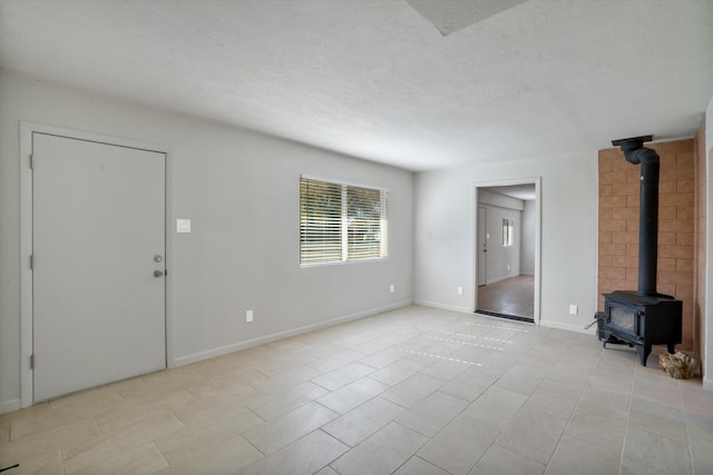 unfurnished living room with a textured ceiling and a wood stove