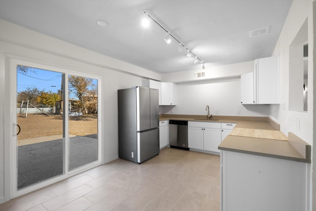 kitchen featuring appliances with stainless steel finishes, sink, and white cabinets