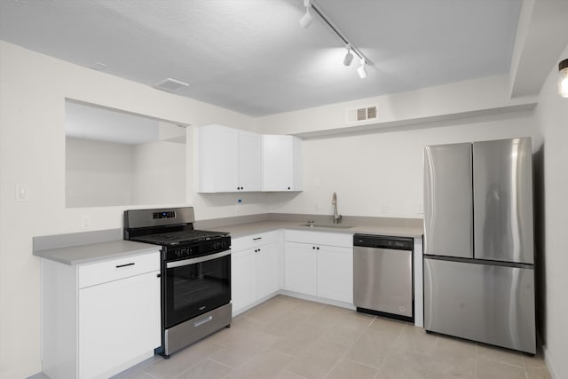 kitchen with stainless steel appliances, white cabinetry, sink, and a textured ceiling