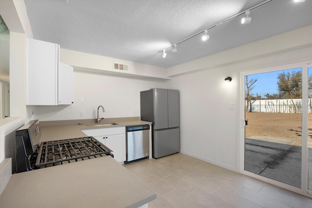 kitchen featuring white cabinetry, sink, stainless steel appliances, and a textured ceiling