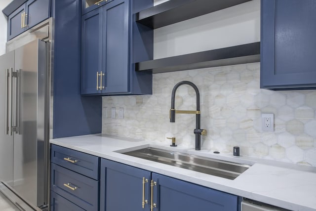 kitchen featuring backsplash, light stone counters, stainless steel appliances, blue cabinets, and sink