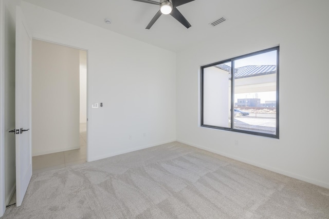 carpeted spare room with ceiling fan