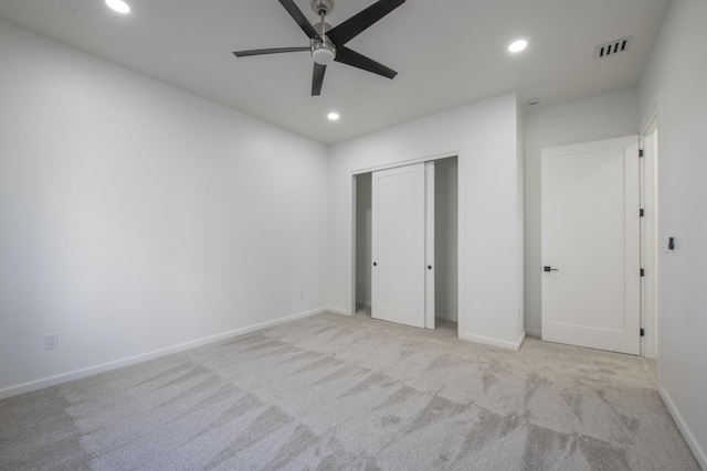 unfurnished bedroom with a closet, ceiling fan, and light colored carpet