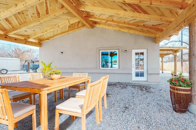 carpeted dining space featuring lofted ceiling with beams, a wealth of natural light, and wood ceiling