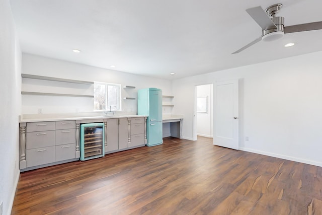 kitchen with ceiling fan, sink, dark wood-type flooring, and beverage cooler