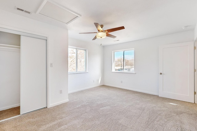 unfurnished bedroom featuring ceiling fan, light colored carpet, and a closet