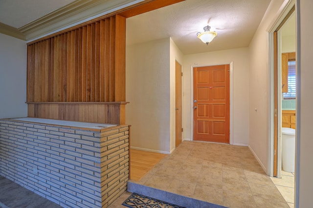 entryway with bar area, a textured ceiling, and light hardwood / wood-style flooring