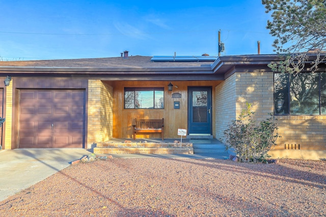 view of front of house featuring solar panels and a garage